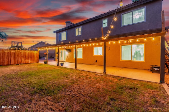 3805 E Desert Flower Ln, Phoenix, AZ 85044 - back of property at dusk featuring a patio, a chimney, and stucco siding