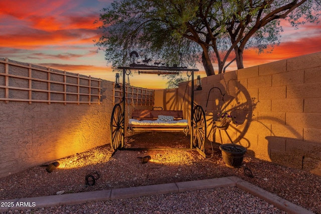 3805 E Desert Flower Ln, Phoenix, AZ 85044 - patio terrace at dusk with an outdoor fire pit and a fenced backyard