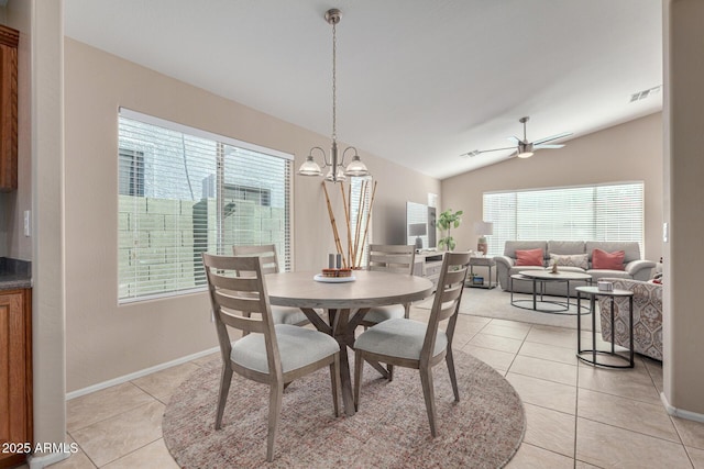 dining room featuring lofted ceiling, ceiling fan with notable chandelier, and light tile patterned floors