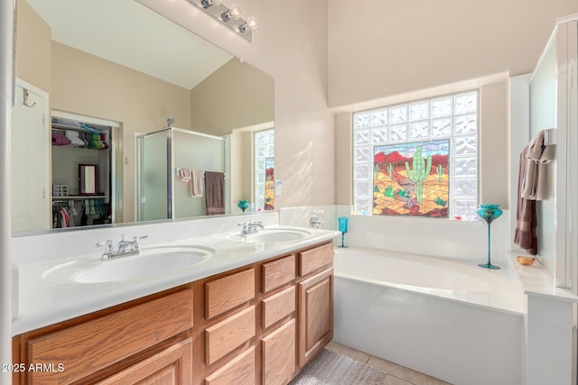 bathroom with vanity, vaulted ceiling, tile patterned floors, and shower with separate bathtub