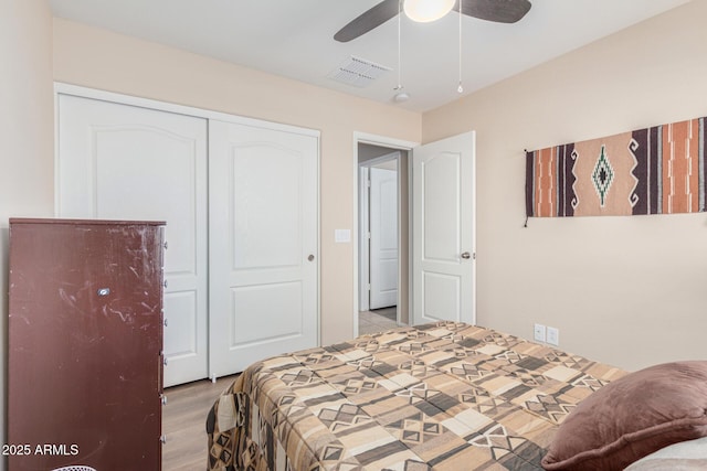 bedroom with ceiling fan, light wood-type flooring, and a closet