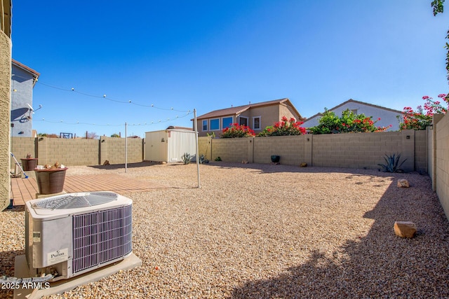 view of yard featuring a storage unit and central AC