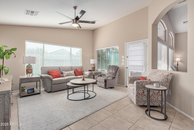 living room featuring lofted ceiling, ceiling fan, and light tile patterned floors