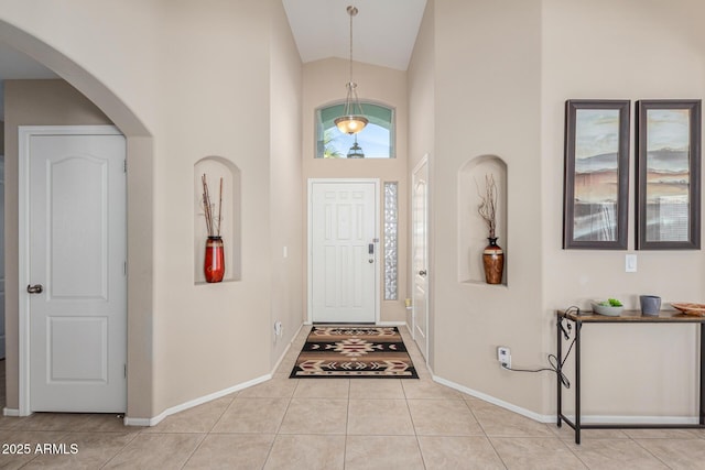 tiled foyer entrance featuring high vaulted ceiling