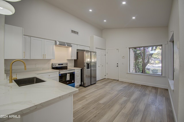 kitchen featuring appliances with stainless steel finishes, light stone counters, sink, high vaulted ceiling, and white cabinets