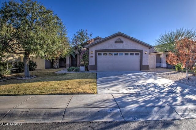 view of front of house featuring a garage and a front lawn