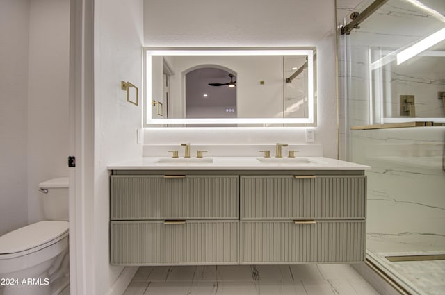 bathroom featuring tiled shower, ceiling fan, vanity, and toilet