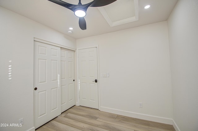 unfurnished bedroom featuring ceiling fan, light hardwood / wood-style floors, and a closet