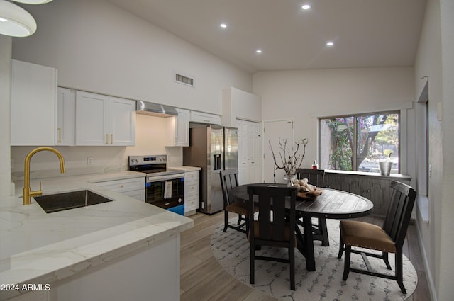 kitchen featuring white cabinetry, sink, stainless steel appliances, light stone counters, and light hardwood / wood-style flooring