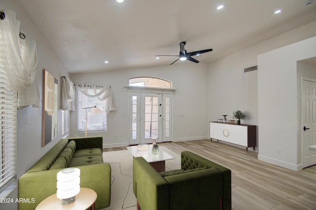 living room with ceiling fan, light wood-type flooring, and vaulted ceiling