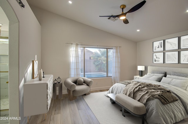 bedroom with ensuite bath, light hardwood / wood-style flooring, ceiling fan, and lofted ceiling