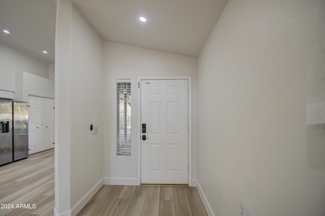 entrance foyer with light hardwood / wood-style floors and lofted ceiling