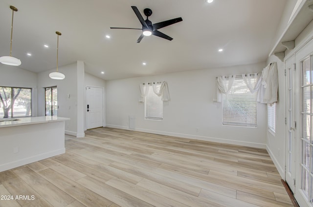 spare room with ceiling fan, light wood-type flooring, and vaulted ceiling