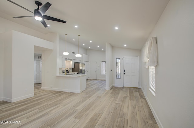 kitchen featuring white cabinetry, stainless steel fridge with ice dispenser, kitchen peninsula, light hardwood / wood-style floors, and decorative light fixtures