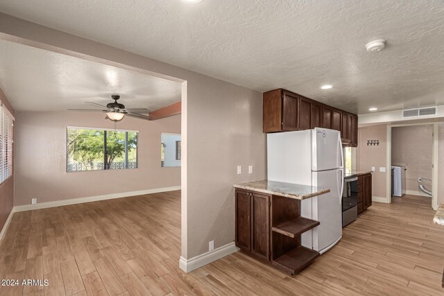 kitchen featuring light wood-type flooring, a textured ceiling, ceiling fan, and white fridge