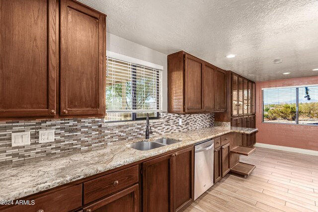 kitchen featuring dishwasher, light hardwood / wood-style floors, sink, and a healthy amount of sunlight