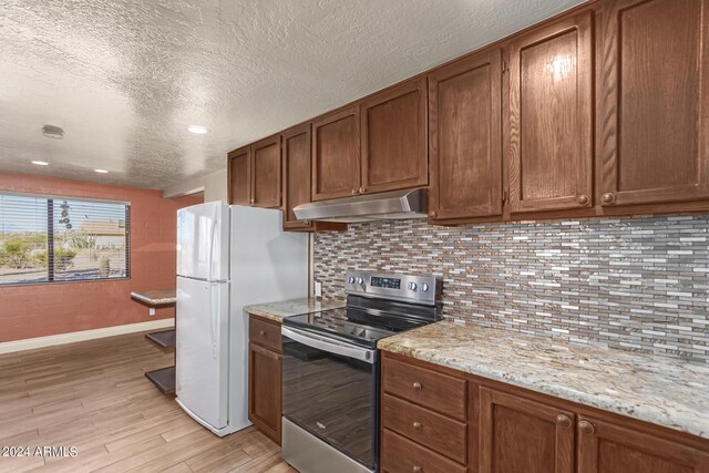 kitchen with backsplash, stainless steel electric stove, light stone countertops, and light hardwood / wood-style flooring