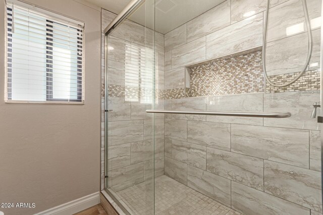 bathroom featuring a shower with door