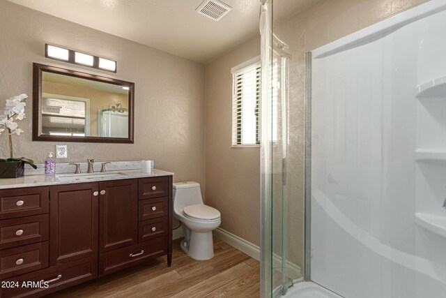 bathroom with wood-type flooring, vanity, and toilet