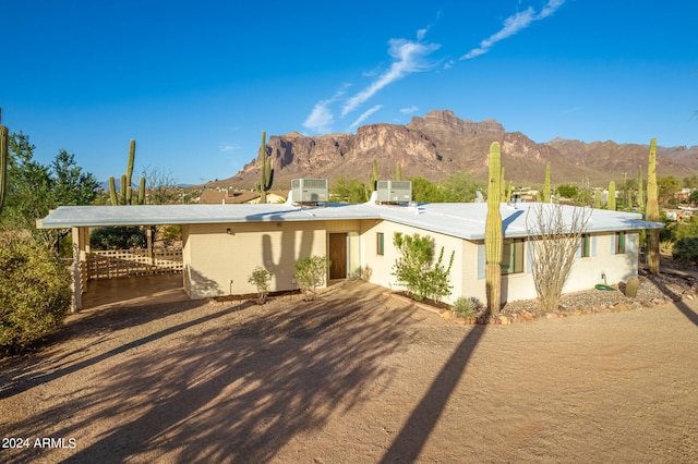 view of front of home featuring a mountain view, central AC, and a carport