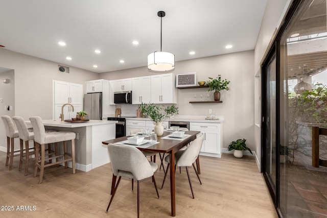 dining room with recessed lighting, light wood-style flooring, and baseboards