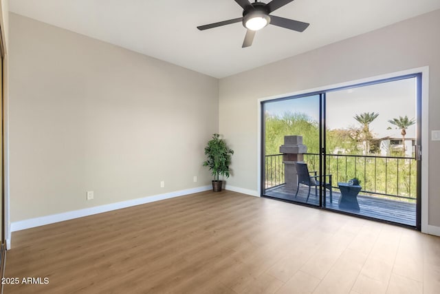 unfurnished room with light wood-style flooring, a ceiling fan, and baseboards