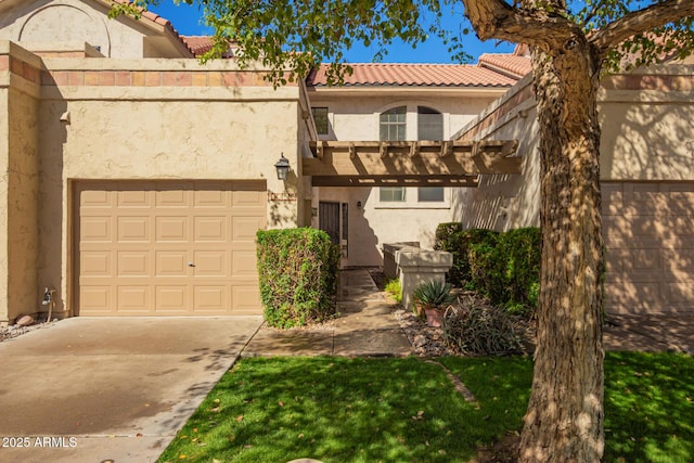 view of front of home with stucco siding, a tiled roof, and concrete driveway