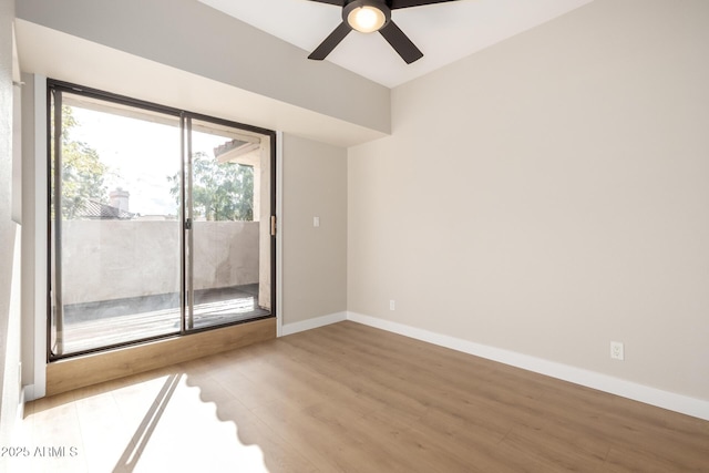 spare room featuring baseboards, wood finished floors, and a ceiling fan