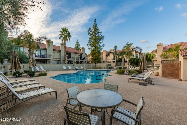 community pool with a patio area, a residential view, and fence