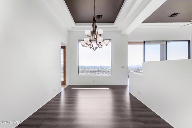 unfurnished dining area featuring dark wood-style floors, a tray ceiling, visible vents, and a notable chandelier