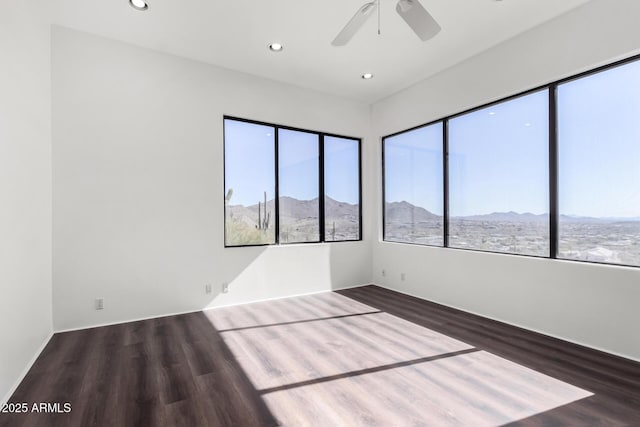 spare room featuring a ceiling fan, recessed lighting, a mountain view, and wood finished floors