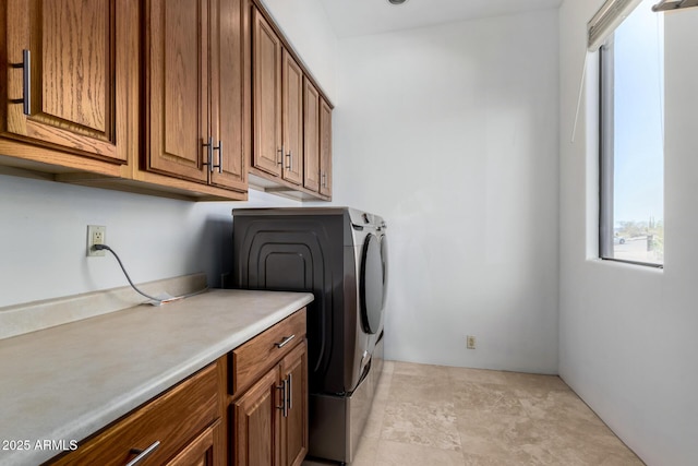 clothes washing area featuring cabinet space and washing machine and clothes dryer