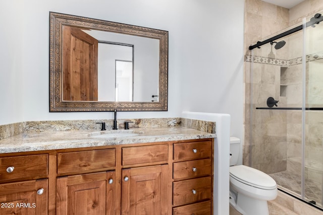 full bathroom featuring vanity, a shower stall, and toilet