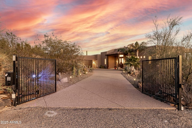 gate at dusk featuring fence