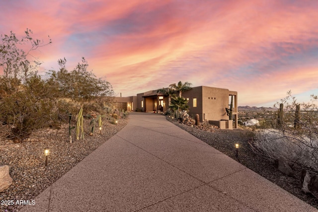 pueblo-style home with driveway and stucco siding