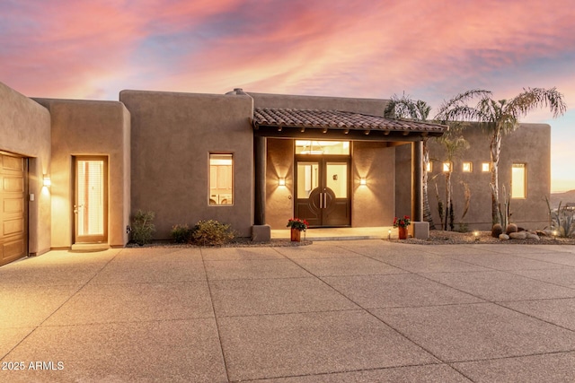 exterior space featuring a tiled roof and stucco siding