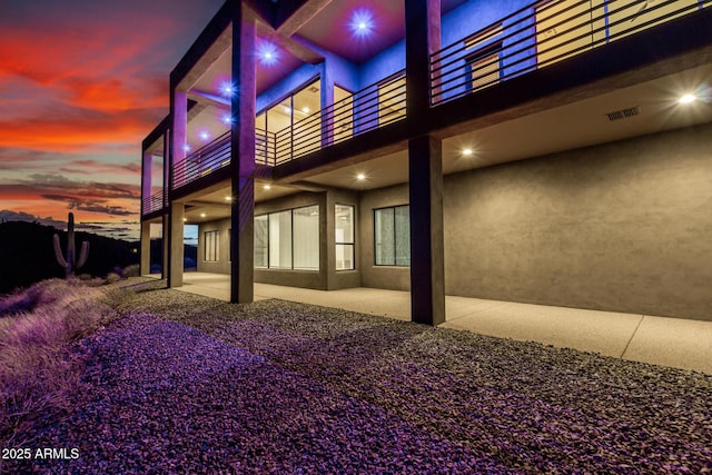 36923 N 31st Ave, Phoenix, AZ 85086 - back of house at dusk with a patio area, a balcony, visible vents, and stucco siding