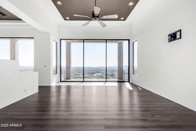 unfurnished room featuring a ceiling fan, a mountain view, wood finished floors, and recessed lighting