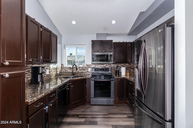 kitchen with lofted ceiling, sink, appliances with stainless steel finishes, and tasteful backsplash