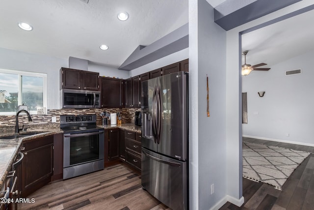 kitchen featuring backsplash, dark wood-type flooring, vaulted ceiling, and appliances with stainless steel finishes