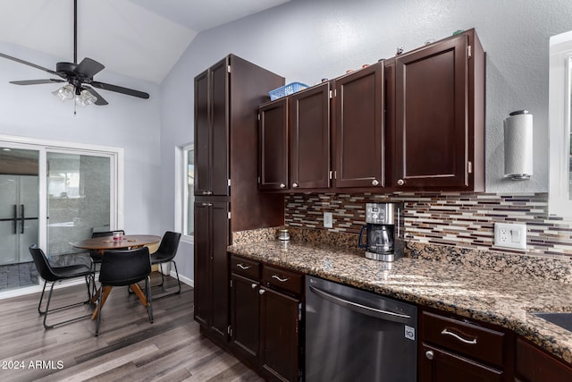 kitchen featuring dishwasher, lofted ceiling, hardwood / wood-style flooring, ceiling fan, and dark stone countertops