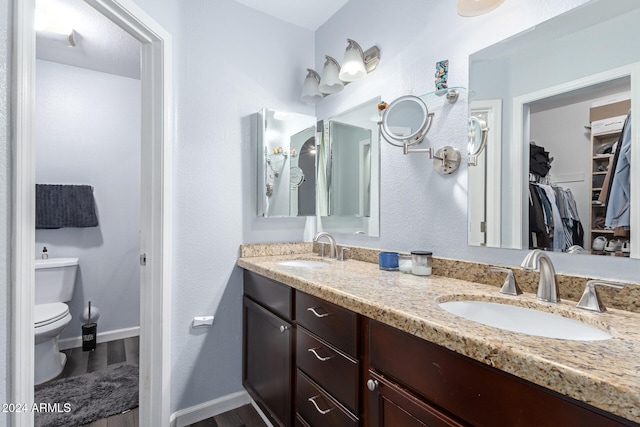 bathroom with hardwood / wood-style flooring, vanity, and toilet