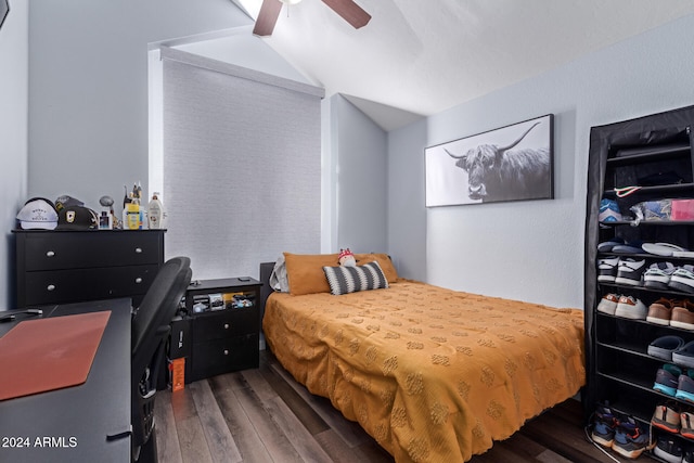 bedroom with ceiling fan, dark wood-type flooring, and vaulted ceiling