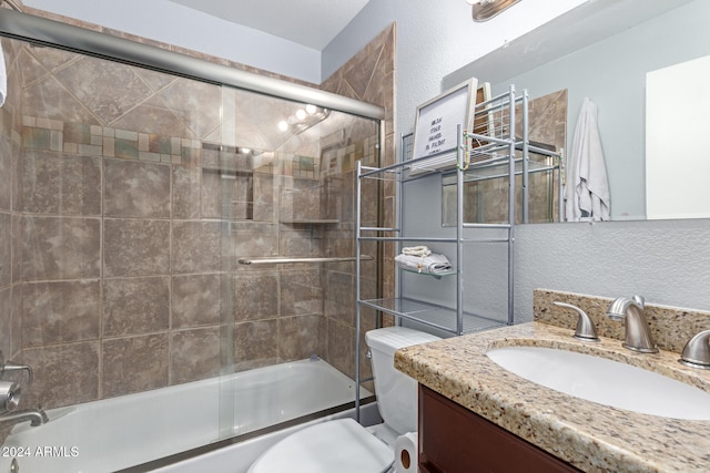 full bathroom featuring vanity, bath / shower combo with glass door, and toilet