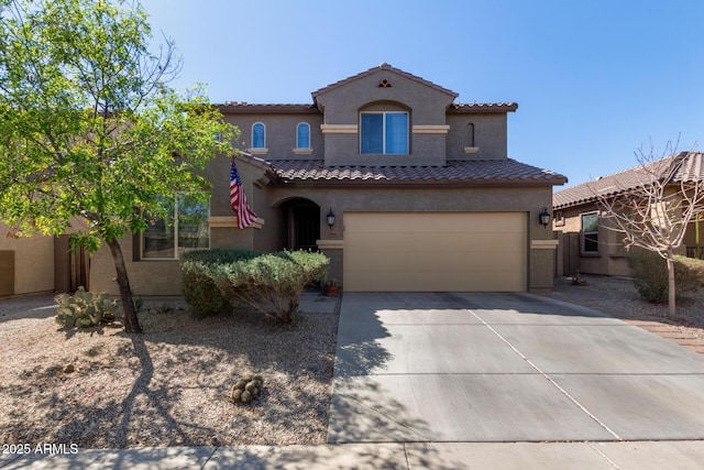 mediterranean / spanish-style home with a tiled roof, driveway, and stucco siding