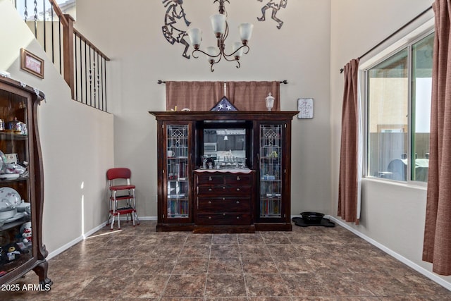 entryway with a chandelier and baseboards