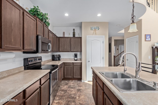 kitchen with recessed lighting, stainless steel appliances, a sink, light countertops, and pendant lighting