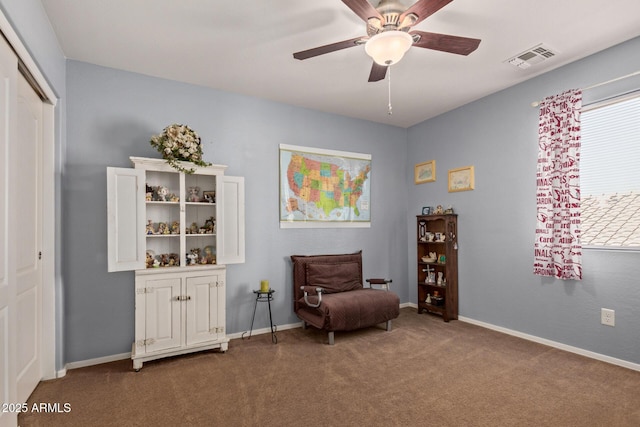 living area featuring baseboards, visible vents, ceiling fan, and carpet flooring