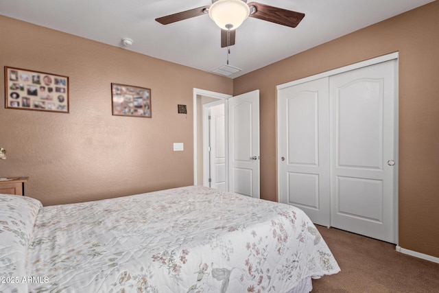 carpeted bedroom featuring a ceiling fan, a closet, and baseboards