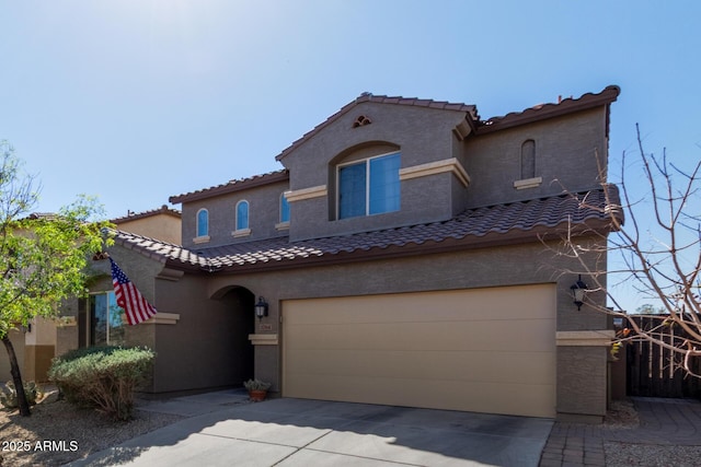 mediterranean / spanish home featuring driveway, an attached garage, and stucco siding